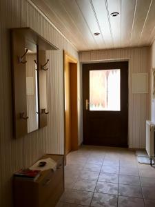 einen Flur mit Tür und Fenster und ein Zimmer mit Tisch in der Unterkunft Ferienwohnung Hänel in Hinterhermsdorf