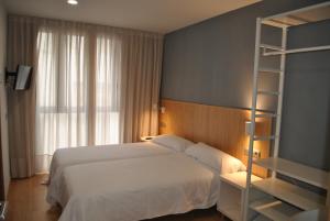 Postel nebo postele na pokoji v ubytování Hostal Universitat