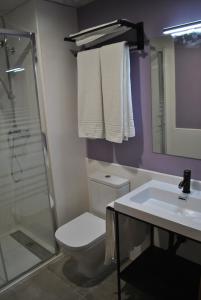 a bathroom with a toilet and a sink and a shower at Hostal Universitat in Cervera
