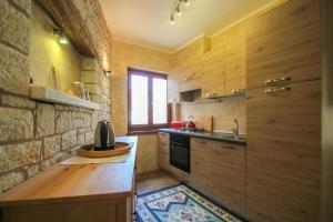 een keuken met houten kasten, een wastafel en een aanrecht bij Casa Rafael 1 in Novigrad Istria