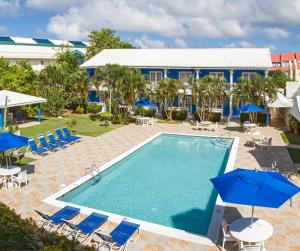 a pool with chairs and umbrellas next to a resort at Bay Gardens Inn in Gros Islet