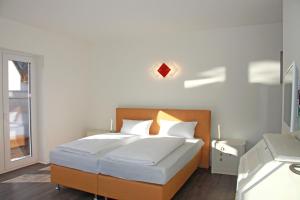 Kehrwieder No5 في هايليغنهافن: غرفة نوم بها سرير بملاءات بيضاء ونافذة