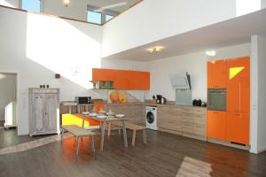 a kitchen with orange cabinets and a table and chairs at Kehrwieder No5 in Heiligenhafen