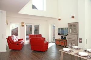 ハイリゲンハーフェンにあるKehrwieder No5のリビングルーム(赤い椅子2脚、テレビ付)