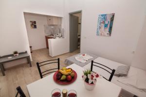 a room with a table with a bowl of fruit on it at Vasilakis Studios & Apartments in Stalís