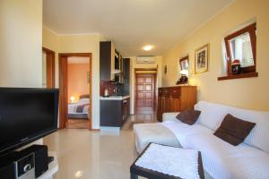 a living room with a white couch and a flat screen tv at Casa Rafael in Novigrad Istria