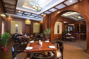 un ristorante con tavoli e sedie in una stanza di Chanakya Bnr Hotel a Rānchī