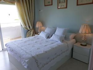 a bedroom with a white bed with two lamps at MAGNÍFICO APARTAMENTO JUNTO A LA PLAYA! in Altea