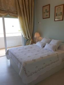 a bedroom with a white bed with a window at MAGNÍFICO APARTAMENTO JUNTO A LA PLAYA! in Altea