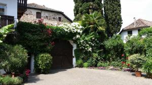 a house with a garage with flowers and plants at Ansitz Wendelstein in Appiano sulla Strada del Vino