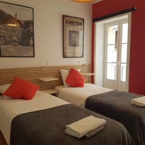 two beds in a room with red and white at Fabulous Apartaments in Lisbon