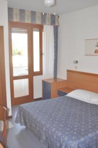 a bedroom with a bed and a sliding glass door at Hotel Villa Candia in Lignano Sabbiadoro