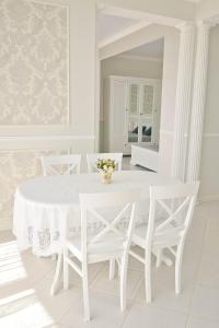 オデッサにあるЭлитная квартира с видом на мореの白いダイニングルーム(白いテーブルと椅子付)