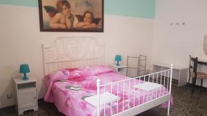 カターニアにあるLanzaのピンクベッド付きのベッドルーム1室、壁に絵画が飾られています。