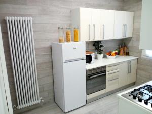 una cucina bianca con frigorifero e radiatore di Residence Diffuso Arcobaleno a Gabicce Mare