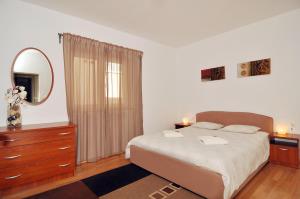 Un dormitorio con una cama, una cómoda y un espejo. en Apartment Babic, en Split