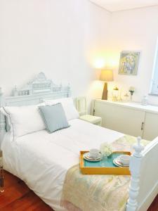 Un dormitorio con una cama blanca y una bandeja. en BS Villas Porto, en Oporto