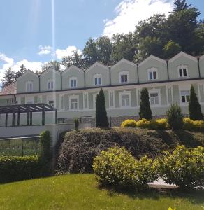 a large white building with a garden in front of it at Vila Park in Rogaška Slatina