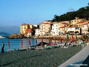 a group of chairs and tables on a beach at Appartamenti Le Spiagge in Marciana Marina