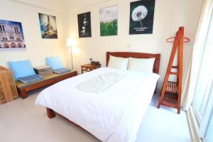 ein Schlafzimmer mit einem Bett und einer Leiter und Bildern an der Wand in der Unterkunft Downshifters House in Tongluo