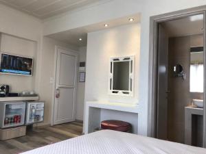 a bedroom with a bed and a mirror and a sink at Sailor's Nautical Concept in Spetses