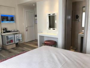 a bedroom with a white bed and a mirror at Sailor's Nautical Concept in Spetses