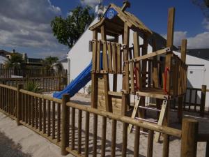 a wooden playground with a slide and a blue slide at Camping Le Bois Verdon in Saint-Jean-de-Monts
