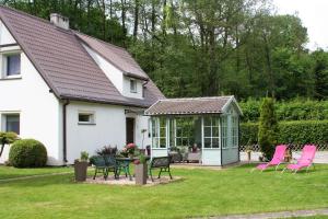 a white house with pink chairs and a patio at Pokoje, apartament NA WYSPIE in Gdańsk