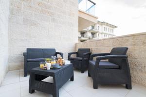 a group of chairs and tables on a balcony at Luxury Two-Bedroom Apartment With Terrace Over Old City View in Jerusalem