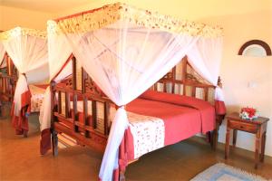 a bedroom with two beds with mosquito nets at Voi Wildlife Lodge in Voi