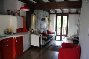 a kitchen with red cabinets and a red chair in a room at Lucanus Cervus in Rascafría