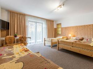 een hotelkamer met 2 bedden en een eethoek bij Willa Bożena 2 in Zakopane