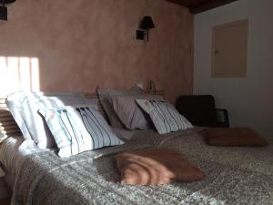 ein Bett mit zwei Kissen darauf in einem Schlafzimmer in der Unterkunft La Maison de Valentine in Jarjayes