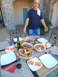 a man standing in front of a table with food at Contessa Apartments in Budva