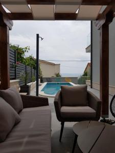 a living room with a couch and a swimming pool at Villa Kozina in Podstrana