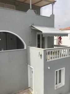 a white house with a white door and a balcony at Sailor's Nautical Concept in Spetses