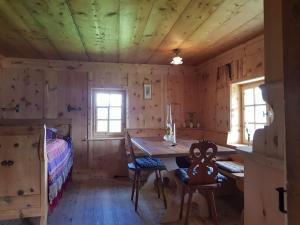 Cette chambre en bois comprend une table et un lit. dans l'établissement Rütland, à Fideris Dorf