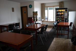 a dining room with tables and chairs and a refrigerator at East Grand Inn in East Grand Forks