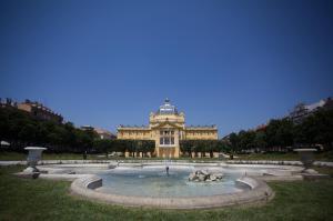 un grande edificio con una fontana di fronte di Apartments S&A a Zagabria