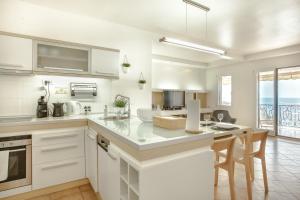 a kitchen with white cabinets and a counter top at Apartment Stefan in Sveti Stefan