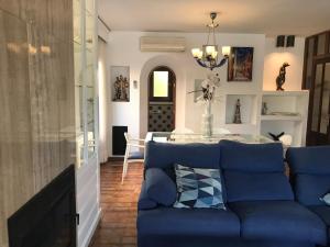 ein Wohnzimmer mit einem blauen Sofa und einem Tisch in der Unterkunft Ca s’Hereu in Cala Millor