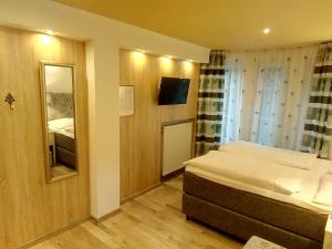 mała sypialnia z łóżkiem i lustrem w obiekcie Pension Wachau w mieście Klagenfurt