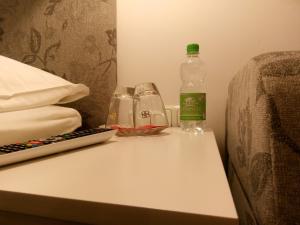 Una botella de agua y dos vasos en una mesa. en Pension Wachau en Klagenfurt