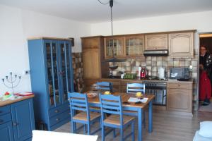 a kitchen with a wooden table and blue cabinets at Apartment Harzgrün 2 in Sankt Andreasberg