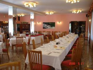 uma grande sala de jantar com mesas e cadeiras brancas em Hotel Ristorante Daino em Pietramurata