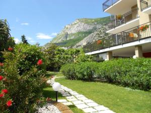 a building with a garden with a mountain in the background at Hotel Ristorante Daino in Pietramurata
