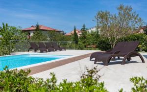 a group of chairs sitting next to a swimming pool at Casa Vidmar in Klimno