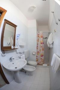 a bathroom with a sink and a toilet and a mirror at Hotel Giglio in Lampedusa