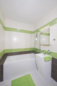 a white bathroom with a tub and a sink at Apartment near city centre with parking place in Prague