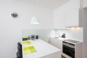 a white kitchen with a counter and a sink at Apartment near city centre with parking place in Prague